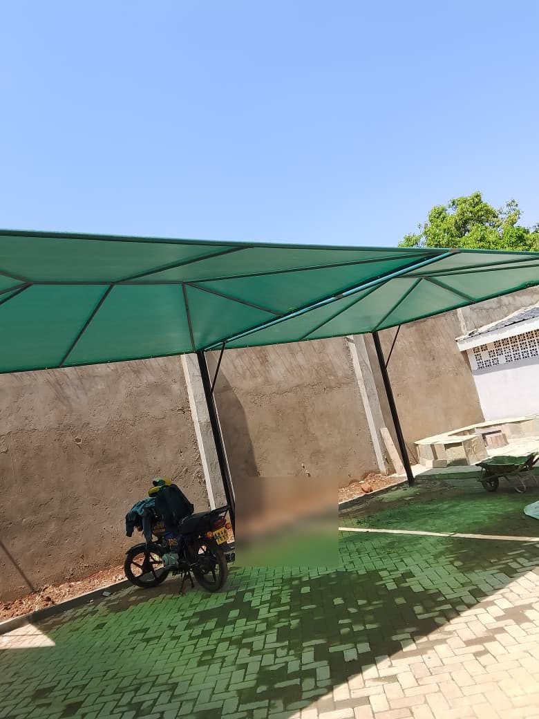 Motorcycle parked under a green shade net