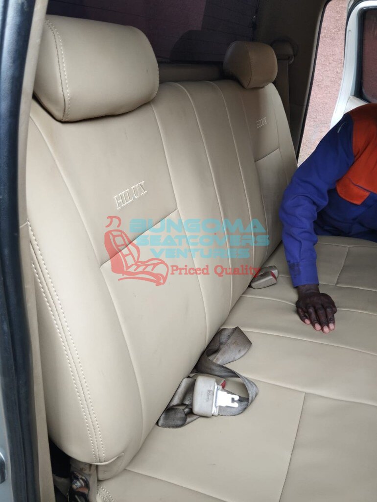 Toyota Hilux beige rear bench seat covers with embroidered HILUX branding by Bungoma Seatcovers Ventures
