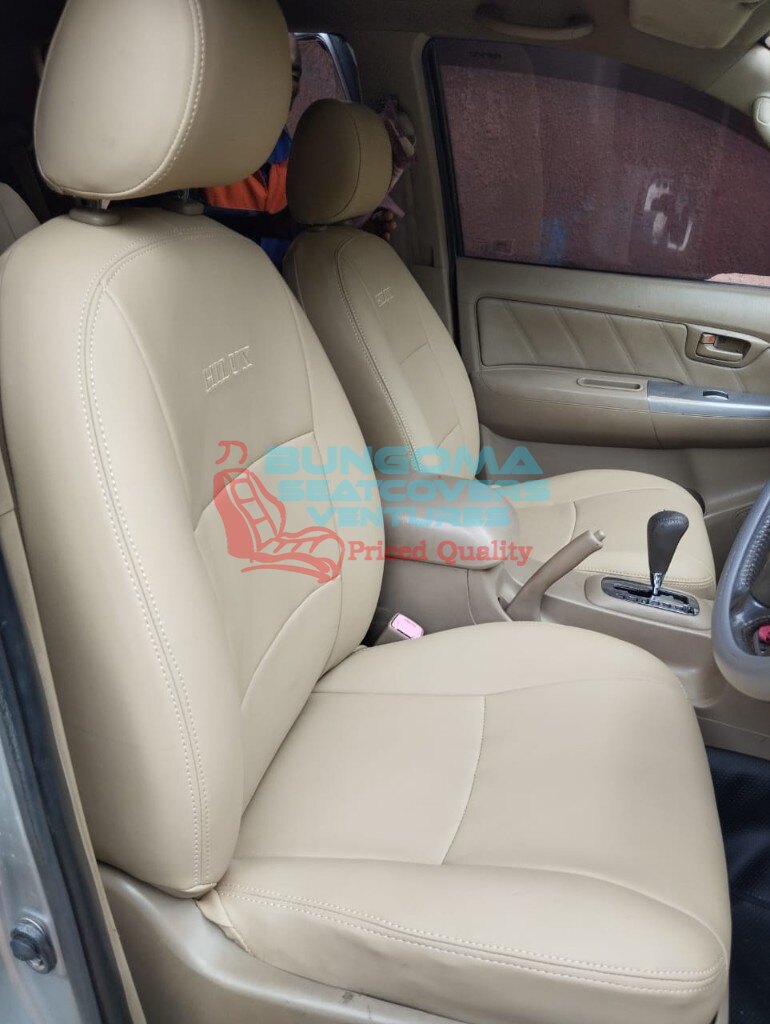 Toyota Hilux beige leatherette seat covers with embroidered HILUX logo and matching door trim by Bungoma Seatcovers Ventures
